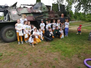 Dzień Dziecka 2019 na ROD im. 40-lecia WP w Pile - dzieci pozujące do zdjęcia przy pojeździe wojskowym