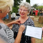 Dzień Działkowca 2022 w Pile- Pani Prezes przypina odznaczenie działkowców kobiecie