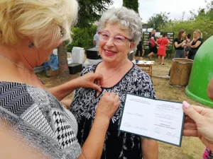 Dzień Działkowca 2022 w Pile- Pani Prezes przypina odznaczenie działkowców kobiecie
