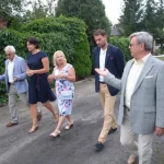 Jubileusz 35-lecia działalności ROD im. 40-lecia WP w Pile - grupa ludzi spaceruje wzdłuż ogrodów działkowych