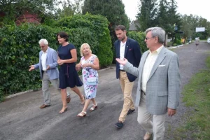 Jubileusz 35-lecia działalności ROD im. 40-lecia WP w Pile - grupa ludzi spaceruje wzdłuż ogrodów działkowych