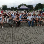 Korso 2019 w Pile - działkowcy siedzący na ławkach pod sceną