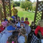 Wizyta Przedszkola - dzieci siedzące w altanie