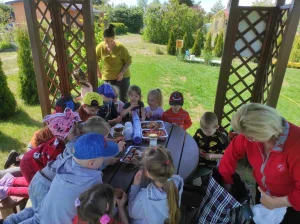 Wizyta Przedszkola - dzieci siedzące w altanie