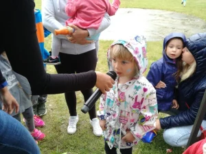 Piknik z okazji Dnia Dziecka - dziewczynka mówiąca do mikrofonu