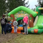 Piknik z okazji Dnia Dziecka - grupa ludzi przy zamku dmuchanym