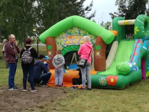 Piknik z okazji Dnia Dziecka - grupa ludzi przy zamku dmuchanym